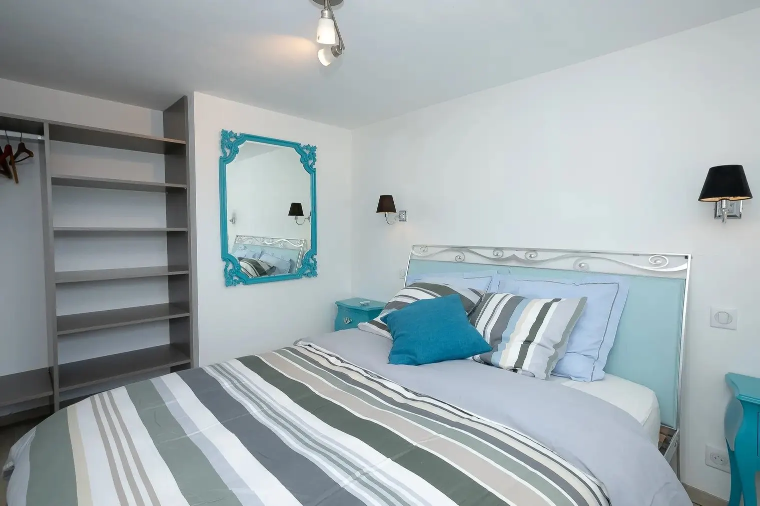 The ground-floor bedroom with its turquoise mirror and shelves