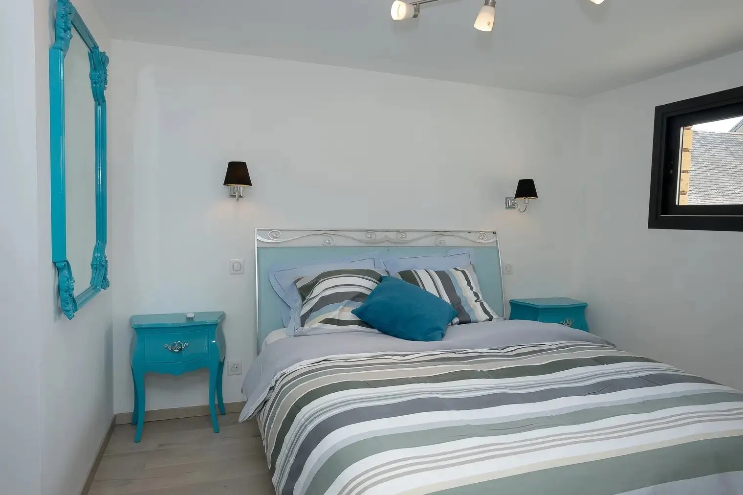 La chambre du rez-de-chaussée, lit double à tête de lit bleu ciel