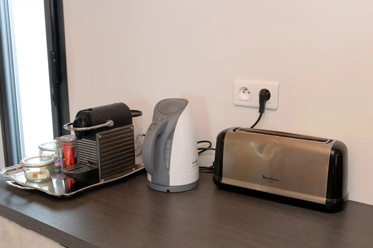 Capsule coffee machine, kettle and toaster on the worktop