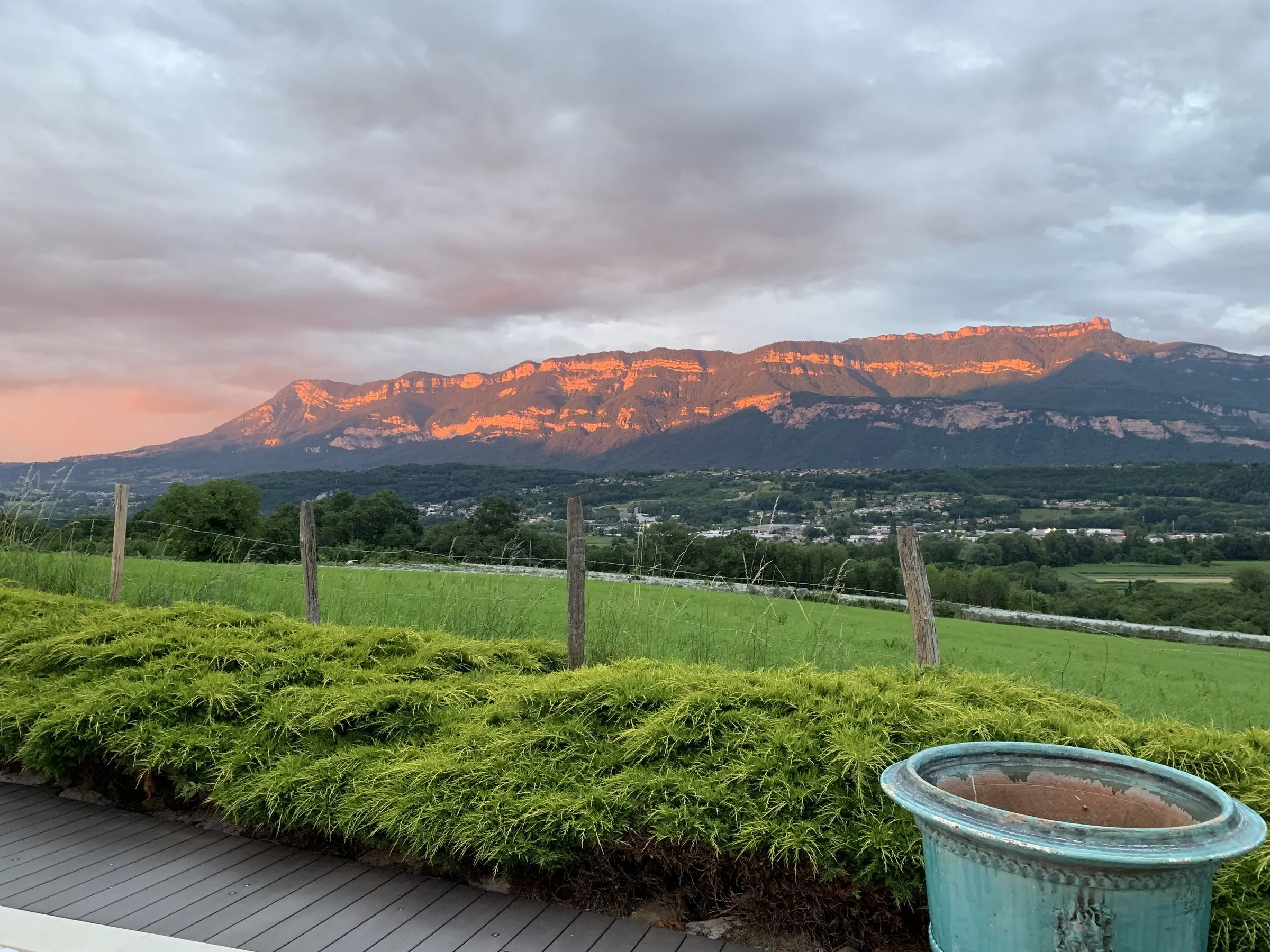 Les falaises du Nivolet et du Revard rougies par le coucher du soleil, vues depuis le jardin du gîte