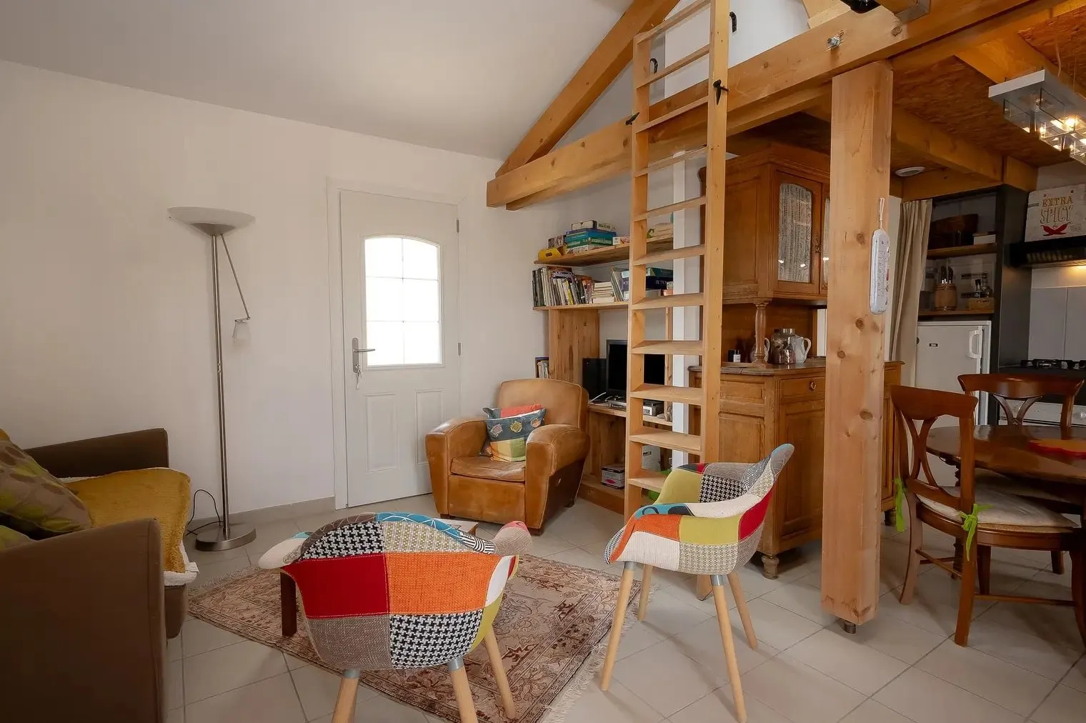Le séjour sous charpente apparente, avec l’échelle de meunier menant à la mezzanine